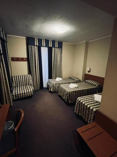 ein Hotelzimmer mit zwei Betten und einer Couch in der Unterkunft Hotel Tre Denti in Cantalupa