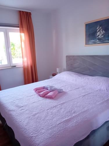 a white bed with two pink towels on it at Tina in Pula