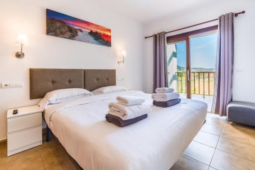 a bedroom with a bed with towels on it at Can Rusiniol 2 in Puig D’en Valls