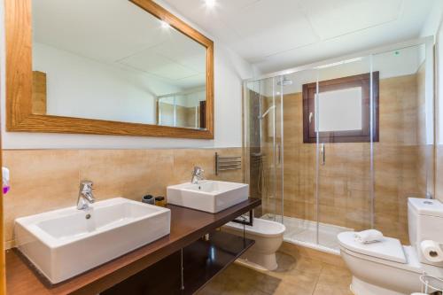 a bathroom with a sink and a toilet and a mirror at Can Rusiniol 2 in Puig D’en Valls