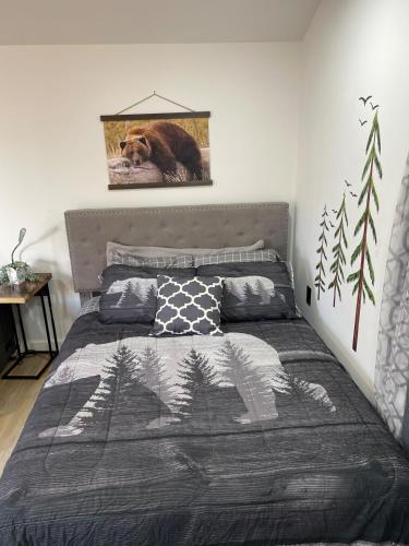 a bedroom with a bed with a bear picture on the wall at Cabin Experience near all in Wilkes-Barre