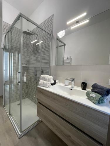 a bathroom with a glass shower and a sink at R&B MiDora Modena in Modena