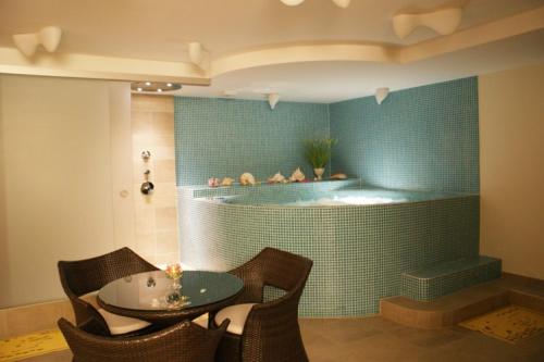 a room with a tub with a table and chairs at Guest House Aštuoni in Palanga
