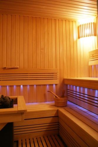 a sauna with a wooden bench and a light at Guest House Aštuoni in Palanga