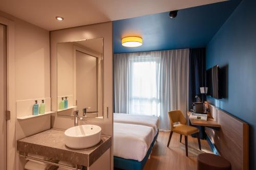 a hotel room with a bed and a sink at Hôtel de la Cité in Nantes