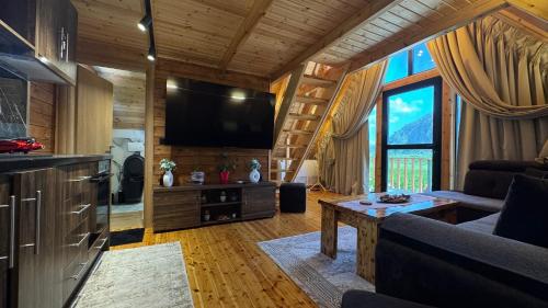 a living room with a couch and a tv at Konispol Mandarin Cabin in Mursi