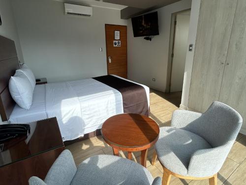 a hotel room with a bed and a table and chairs at Hotel Inclan in Lima