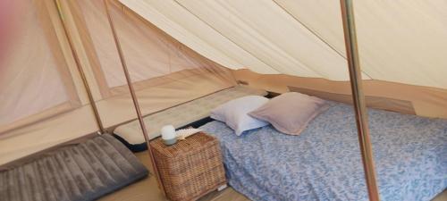 a bedroom with a bed in a tent at Camping à la Ferme de la Marette in Gluiras