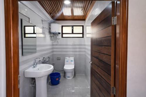 a bathroom with a sink and a toilet at Kanchankanya Hill Resort in Takdāh