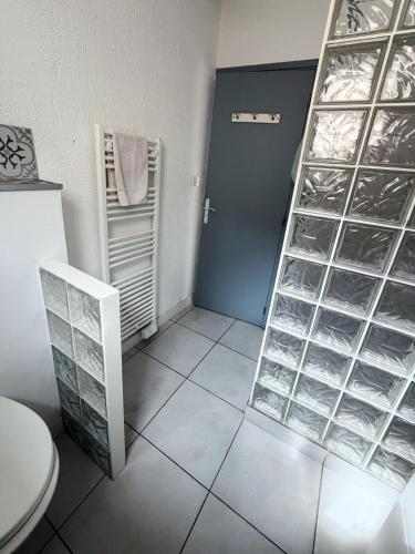 a bathroom with a toilet and a shelf with water bottles at Maison 1 chambre in Hyères