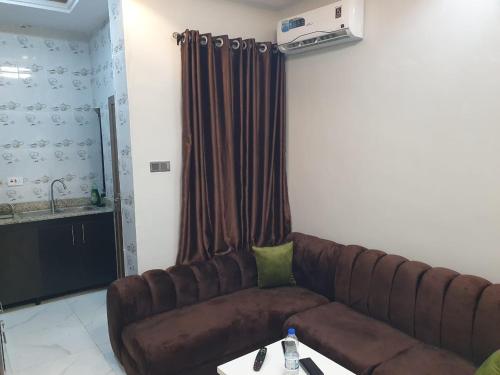 a living room with a brown couch and a table at Torax Lodge in Ibadan