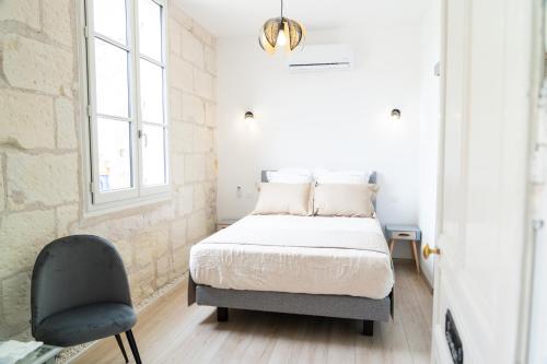 a bedroom with a bed and a chair at Parnaydisiaque in Parnay