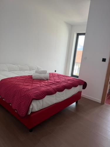 a bedroom with a large bed with a red comforter at Casa Albertina in Mogofores