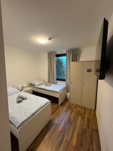 a room with two beds and a television in it at Haven Lodge Komfortable Unterkunft für Monteure, Firmen und Gruppen in Bremerhaven in Bremerhaven