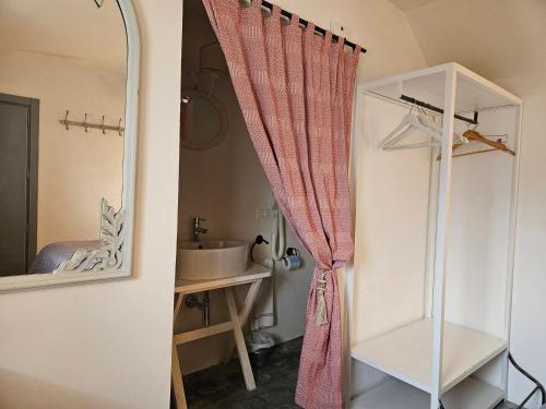 a bathroom with a shower curtain and a sink at Masseria Spartivento in Melendugno