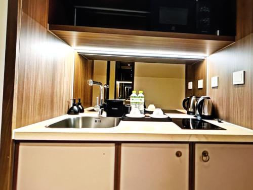 a kitchen with a sink and a mirror at Aura Seaviews Suites in Phan Thiet