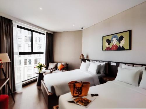 a hotel room with two beds and a window at Aura Seaviews Suites in Phan Thiet