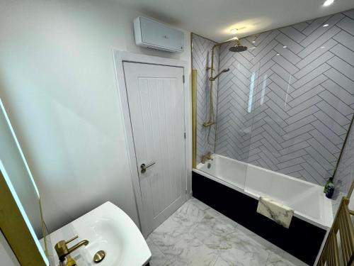 a bathroom with a sink and a bath tub at Central 3BR home with Parking in Aberdeen