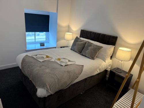 a bedroom with a bed with two towels on it at Central 3BR home with Parking in Aberdeen