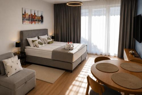 a bedroom with a bed and a table and chairs at Apart Studio Śródmieście in Gdańsk