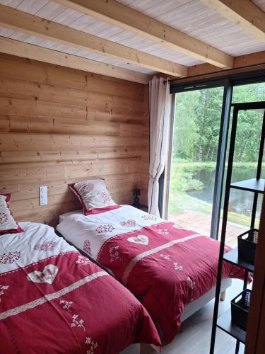 a bedroom with two beds in a log cabin at Chalet des Briseux in Saint-Maurice-sur-Moselle
