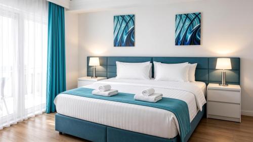 a bedroom with a large bed with two towels on it at White Tower Mamaia Beach 602 in Mamaia