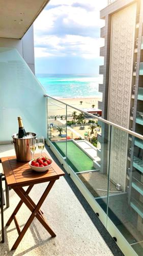 a balcony with a table with a bowl of fruit and wine glasses at White Tower Mamaia Beach 602 in Mamaia