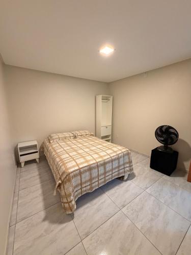 a bedroom with a bed with a plaid blanket at Comfort Ton House in Juazeiro do Norte