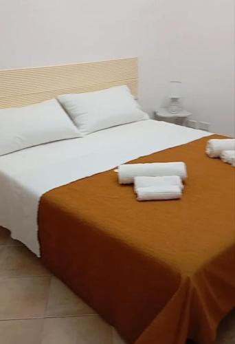 a large bed with two rolled towels on it at Casa Leone in Sciacca
