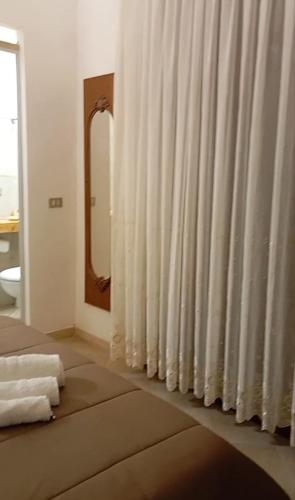 a white curtain in a room with a mirror at Casa Leone in Sciacca