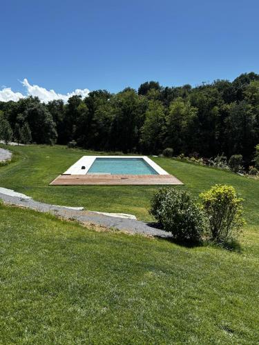 a swimming pool in the middle of a grassy field at La Torre Granaia in Serravalle Scrivia