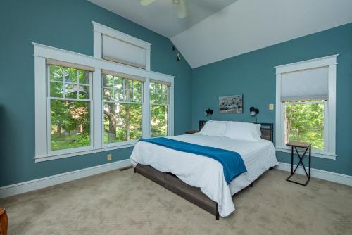 a blue bedroom with a bed and two windows at The Wander Inn in Black Mountain