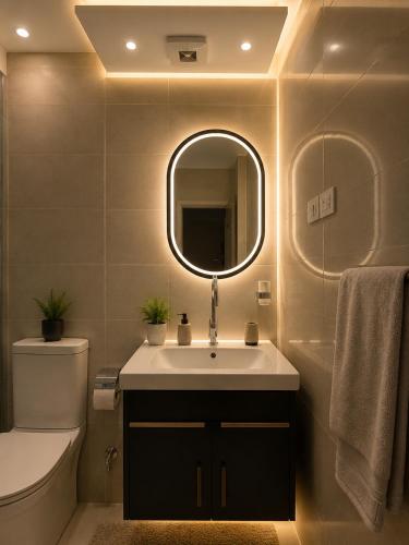 a bathroom with a sink and a mirror and a toilet at Dima Plaza Pyramids View in Cairo