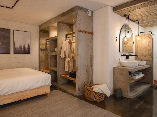 a bedroom with a bed and a sink and a mirror at GuestReady - ALMA - Island House in Faial da Terra