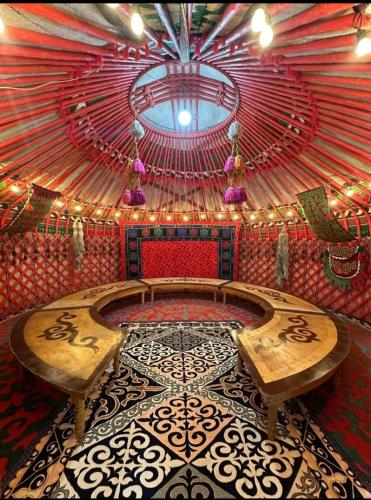 a room with two benches and a large ceiling at Юрта in Karakol