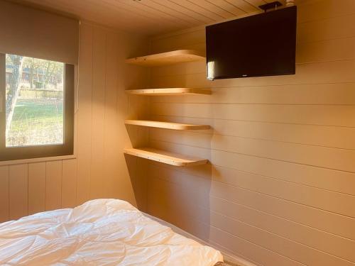 a bedroom with a wall with shelves and a tv at Natuur, Rust & Ontspanning in de Ardennen in Rendeux