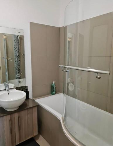 a bathroom with a sink and a bath tub and a sink at Modern 2 Bed 1 Bath Apt With Complex Pool in Johannesburg
