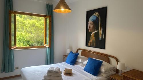 a bedroom with a bed with a painting of a woman at Mare Mio Talamone in Talamone