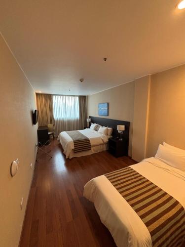 a hotel room with two beds and a window at Amérian Rosario in Rosario
