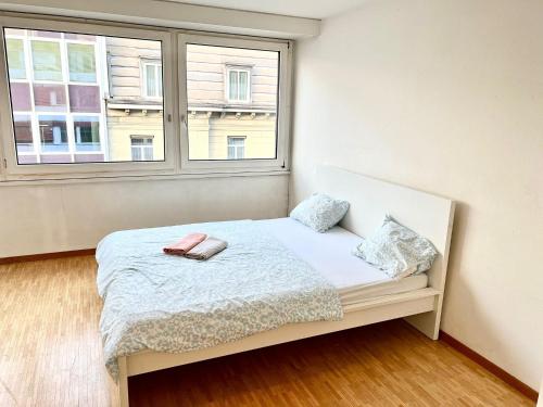 a small bedroom with a bed with a window at Downtown Flats - Lake Lucerne in Lucerne