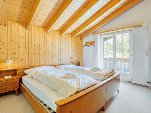 a bedroom with two beds and a large window at Sonniges Chalet mit fantastischem Bergblick in Lenk
