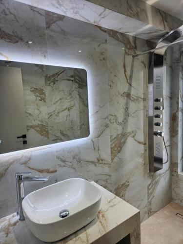 a bathroom with a sink and a mirror at Sage Villas in Plataria