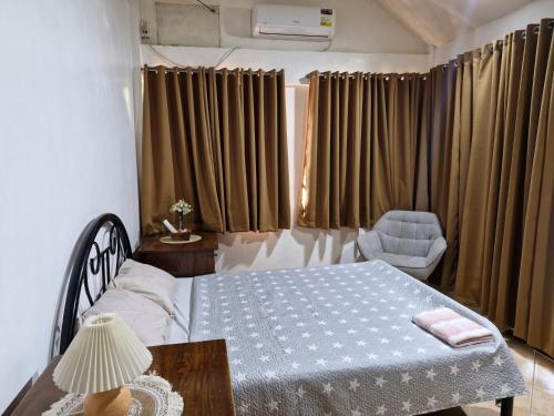 a bedroom with a bed and a table and a chair at Casa Maria in Sibulan