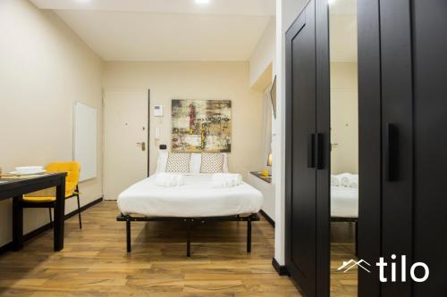 a bedroom with a bed and a desk and a table at City center 4’|Studio|wifi|By tilo in Genoa