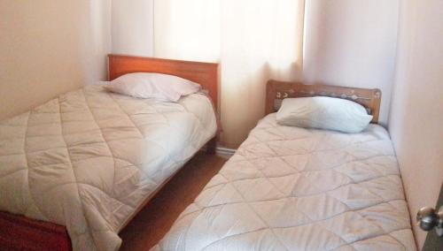 two twin beds in a room with a window at Departamento Los Andes in Los Andes