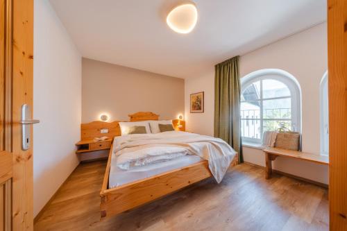 a bedroom with a large bed and a window at Kreuzwegerhof Nals - Historic Nature Stay with Pool near Meran & Bozen in Nalles