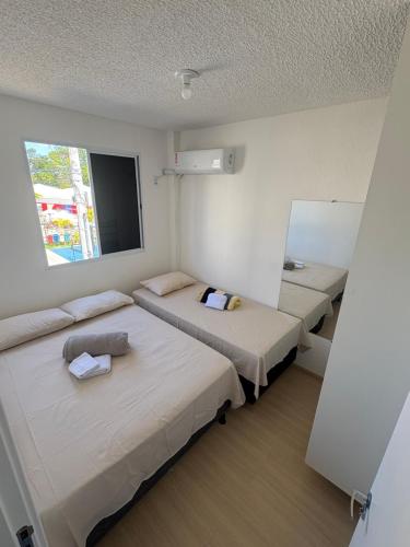 a room with two beds and a window at Aconchego estrada do coco in Camaçari