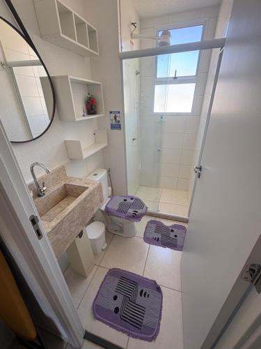 a bathroom with a sink and a toilet and a mirror at Aconchego estrada do coco in Camaçari