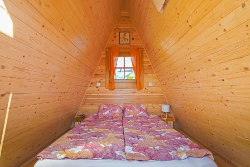 a bed in a wooden cabin with a window at Glamping by the Old Mill in Preddvor