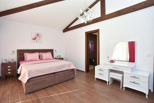a bedroom with a bed and a dresser and a window at Vila sa bazenom Emar, Budva in Krimovice